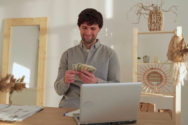 Smiling business man counts money while sitting in the office